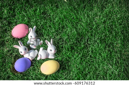 bunny rabbit with pink easter egg on green grass for background and copy space