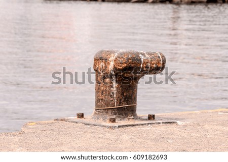 Photo picture of a Rusty metal mooring bolard for big ship