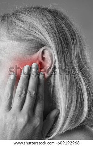 Woman with earache, ear pain closeup, black and white photo with red spots
