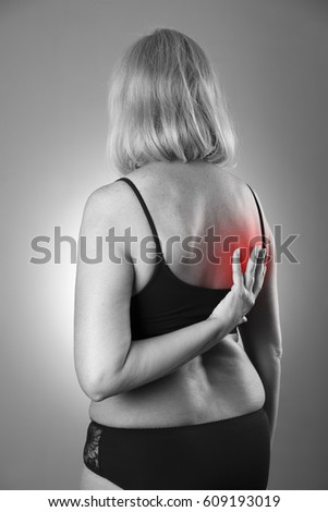 Back pain, massage of female body, ache in woman's body, black and white photo with red spots