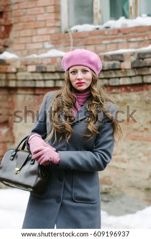 Girl in a gray coat and a pink beret in the courtyard of an old house / The picture was taken in Russia, in the city of Orenburg, on Kobozev Street.