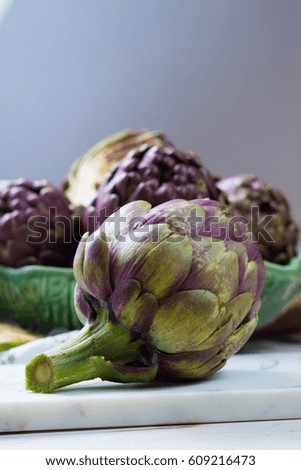 Fresh big Romanesco artichokes green-purple flower heads ready to cook seasonal food