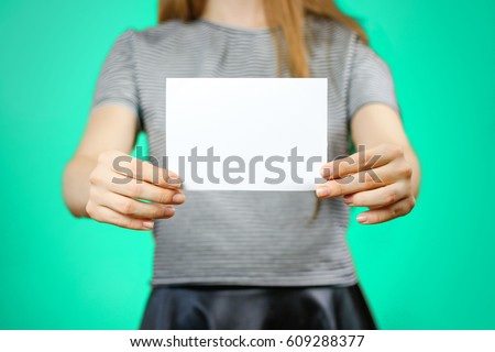 Woman showing blank white flyer paper. Leaflet presentation. Pamphlet hold hands. Girl show clear offset paper. Sheet template. Booklet design sheet display read first person.