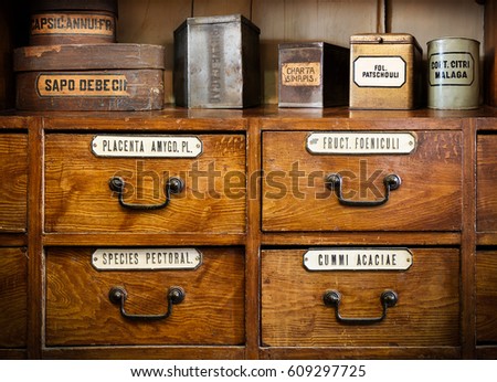 Bottles on the shelf in old pharmacy. The labels on bottles and a shelf  inscription in Latin language. Translation: gum Arabic, chalk white, turmeric root, thoracic collecting, soap, mustard, cocoa