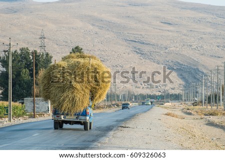 Truck loaded with straw bales on country road in Shiraz Southern of Iran