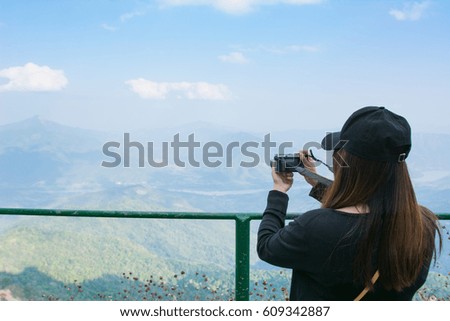 Happy girl on vacation taking picture on mountain background.