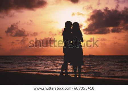 young romantic loving couple hug at sunset beach