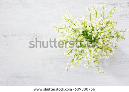 Bouquet of Lilies of the Valley  over  white  wooden background 