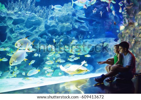 excited father and son watching the marine life in oceanarium Royalty-Free Stock Photo #609413672