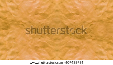 Orange background with fingerprints made from plasticine.  Royalty-Free Stock Photo #609438986