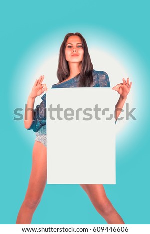Cute woman holding white blank signboard. Smiling female model on blue background. Concept for tagline.