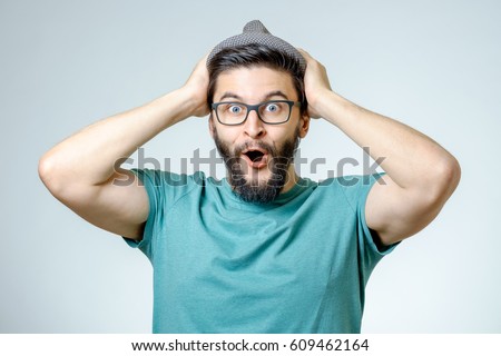 Man with shocked, amazed expression isolated on gray background Royalty-Free Stock Photo #609462164