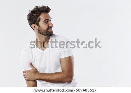 Smiling guy in white t-shirt, looking away