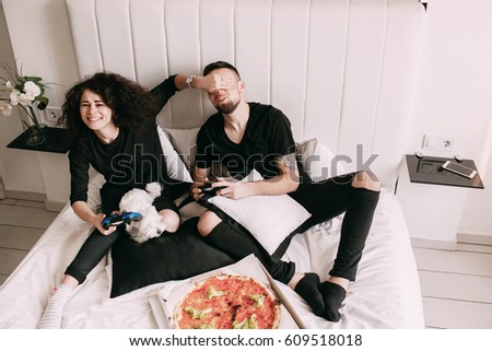 Girl closes man's eyes while they play PS Royalty-Free Stock Photo #609518018