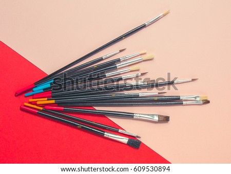 Art paint brushes isolated on pink and red background. Art concept.