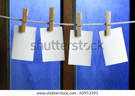 four photo paper attach to rope with clothes pins on window background