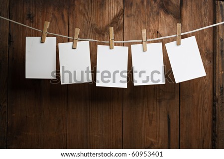five photo paper attach to rope with clothes pins on wooden background