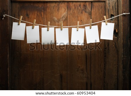 seven photo paper attach to rope with clothes pins on wooden background