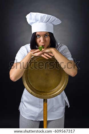 Young woman in chef uniform with big copper pan. Beauty Brunette Woman with Perfect Makeup. Beautiful Professional  Make-up .