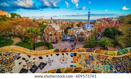Barcelona, Catalonia, Spain: the Park Guell of Antoni Gaudi at sunset. The two buildings at the entrance of the park and Gaudi's mosaic work on the main terrace.
