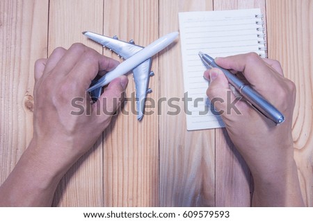 Unidentified man hand writing planning and working with airplane model.