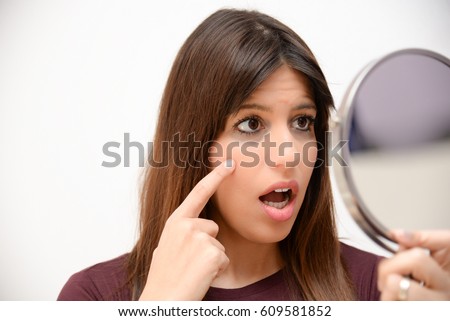 astonished woman with dark circles in the mirror Royalty-Free Stock Photo #609581852