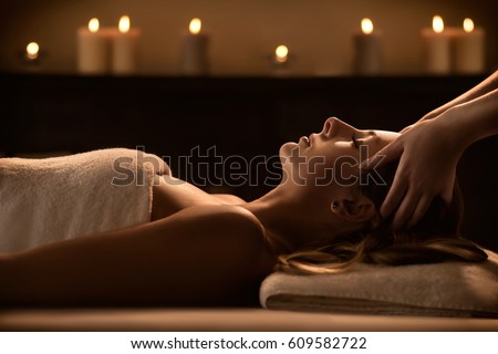 Young woman enjoys massage in a luxury spa resort Royalty-Free Stock Photo #609582722