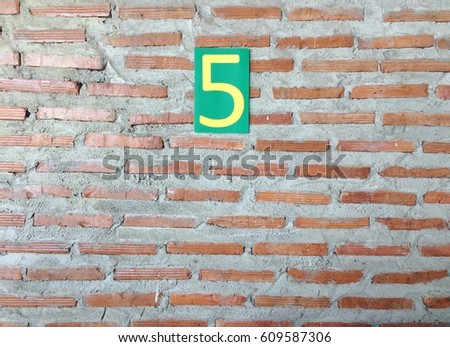 Number five sign put at brick wall texture background