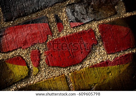 The texture of the national flag of Germany (photo shop) is painted on a brick old masonry with small gravel