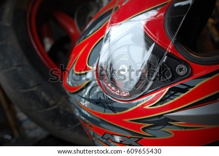 A motorcycle helmet pictured with a street bike.
