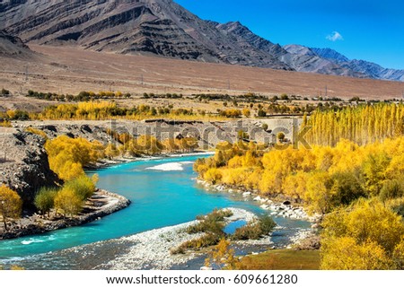 Blue River in autumn forest and mountain range. Nature composition.
