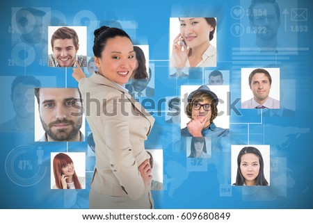 Smiling asian businesswoman pointing against blue background