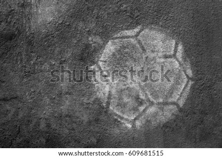 Soft focus, soccer ball printed on cement wall, black and white background.