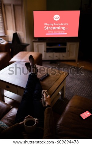 Composite image of text with wi-fi symbol against man with laptop on table watching television