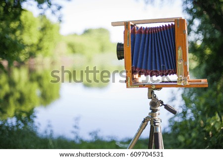 wooden camera plate, antique retro camera, medium format, professional photographic, vintage camera on the background of summer landscape, forest and lake