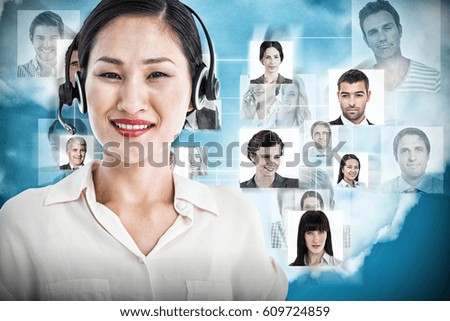 Beautiful smiling female executive with headset against blue background
