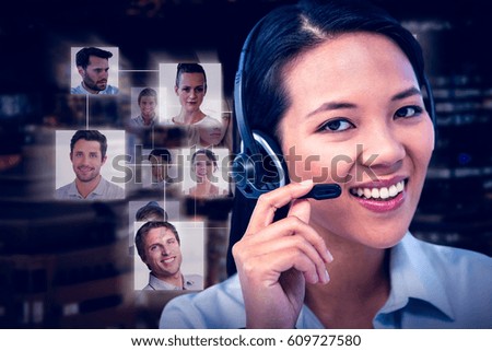 Smiling businesswoman using headset against glowing modern buildings in city