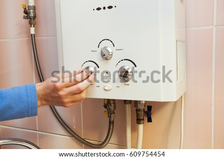 Men hand regulate the power of hot water in Gas water heater