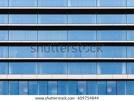 Modern building facade, wall made of blue glass, steel frames and concrete floors, frontal view, flat background photo texture