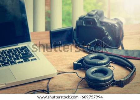 Workspace with notebook keyboard, camera on wooden background. View from above, office table desk