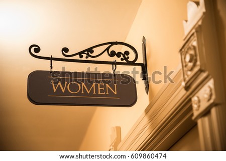 Ornate interior door frame with wrought iron women's bathroom sign