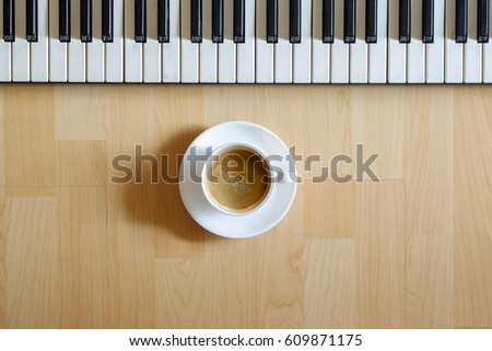 Electronic Piano Keyboard and Coffee on wood background.
