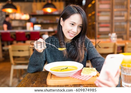 Woman enjoy her soup and taking selfie