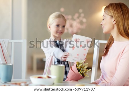 Pretty youngster giving handmade greeting-card to her mom