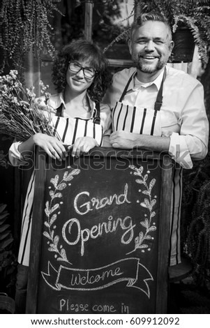 Adult Man and Woman Standing with Grand Opening Sign