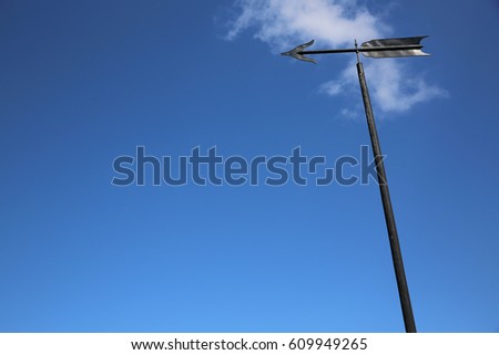 Weather Vane or Wind Direction Indicator against blue Sky