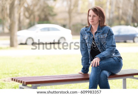 Cute woman sitting on the bench in the park