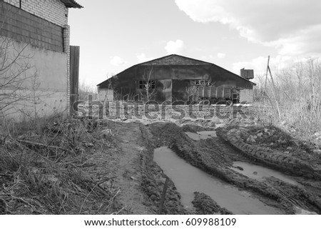 Dirty road and buildings. Abandoned farm
