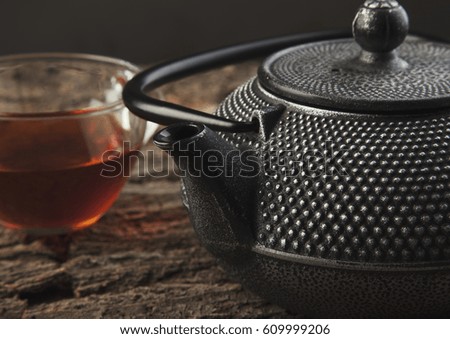 Teapot and cup on a wooden table close up photo