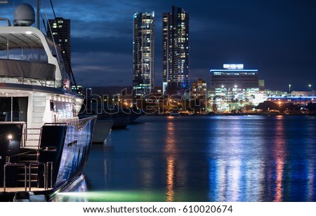 View Of A Luxury Modern Boat In A Marina Reflecting In The Canal And Overlooking The Lit City Skyline At Night, Main Beach, Gold Coast, Queensland, Australia